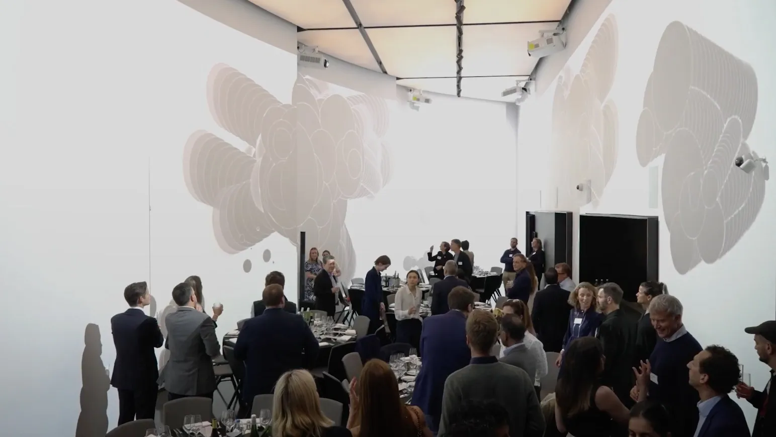 A crowd in a white gallery under large paper sculptures, at SXSW London